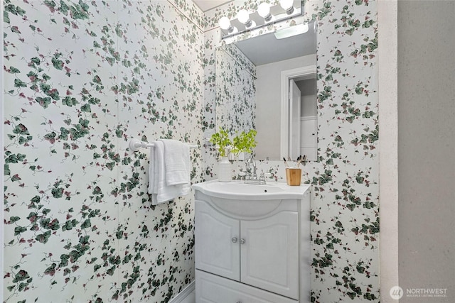 bathroom featuring vanity and wallpapered walls