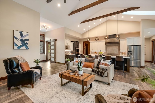 living area featuring a barn door, light wood-style flooring, high vaulted ceiling, and beam ceiling