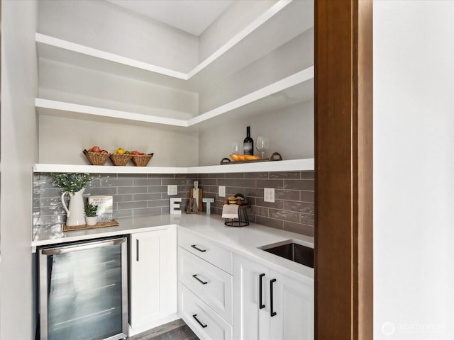 bar featuring bar area, backsplash, and beverage cooler