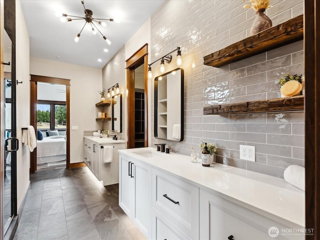 bathroom with marble finish floor, tasteful backsplash, connected bathroom, baseboards, and vanity