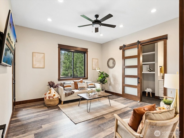 living area featuring recessed lighting, a barn door, and wood finished floors