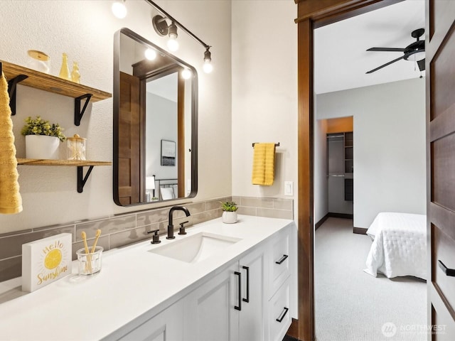 bathroom featuring decorative backsplash, a ceiling fan, and vanity