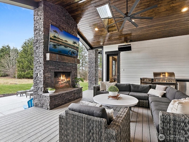 deck featuring ceiling fan, grilling area, an outdoor kitchen, and an outdoor living space with a fireplace