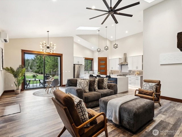 living area with a wall unit AC, high vaulted ceiling, light wood-style flooring, a skylight, and a chandelier