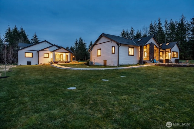 view of front of property with cooling unit and a front yard