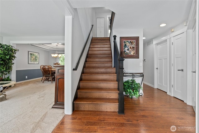 stairs with visible vents, baseboards, a chandelier, carpet floors, and recessed lighting