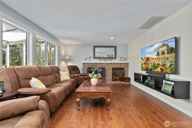 living area featuring recessed lighting, visible vents, wood finished floors, and a fireplace