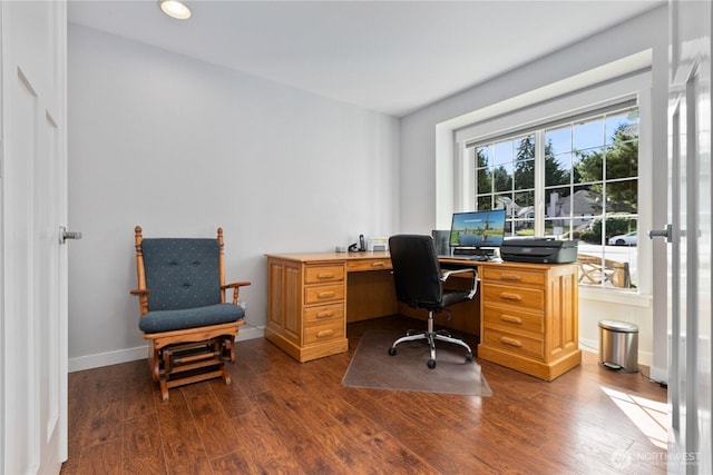 home office with dark wood-type flooring and baseboards