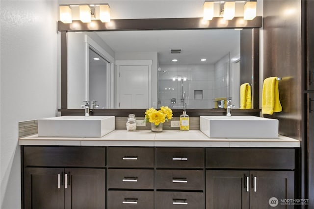 full bathroom featuring a shower stall, double vanity, visible vents, and a sink