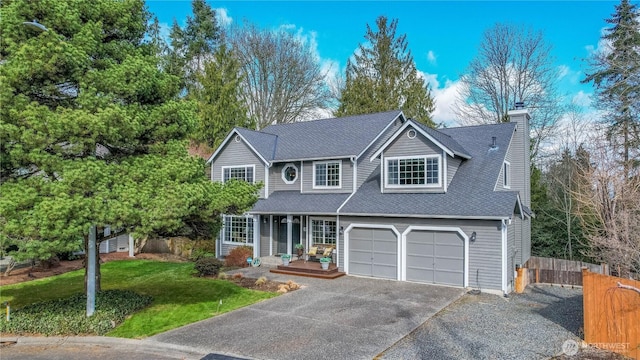 traditional home featuring fence, driveway, a chimney, a front lawn, and a garage