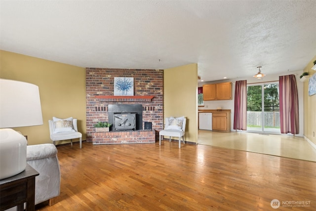 living room featuring light wood-type flooring and a textured ceiling