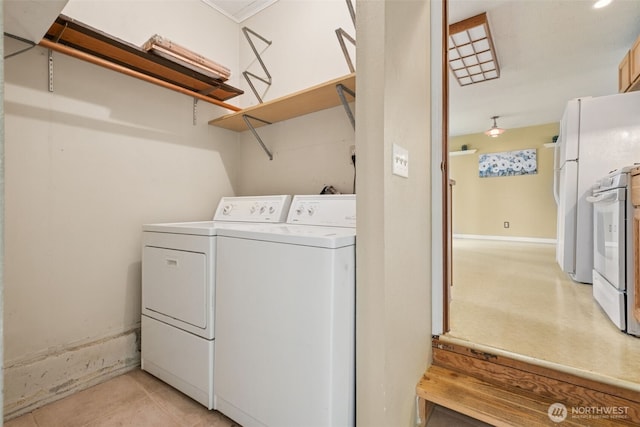 clothes washing area with independent washer and dryer, light tile patterned flooring, and laundry area