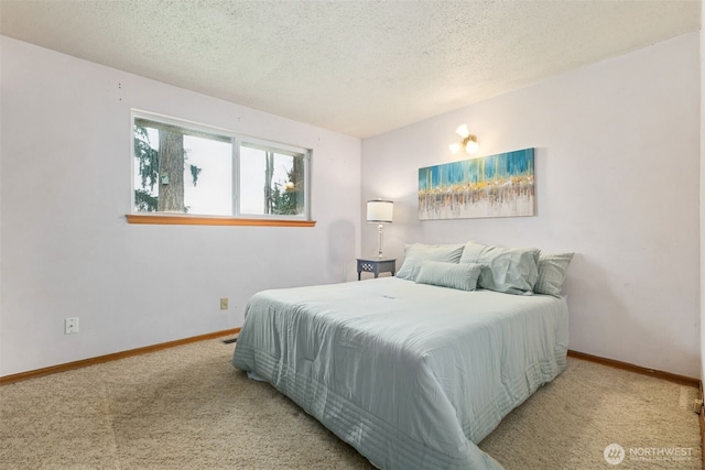 carpeted bedroom with baseboards and a textured ceiling