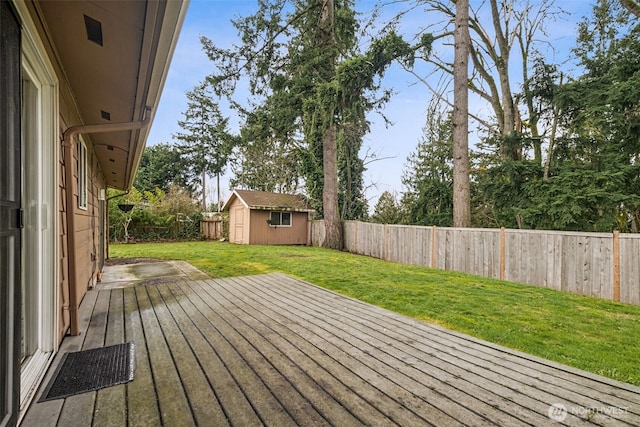 deck with an outbuilding, a fenced backyard, a lawn, and a shed