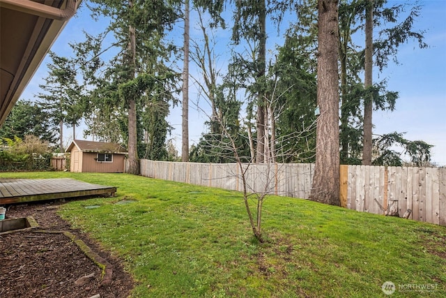 view of yard with an outbuilding, a fenced backyard, and a shed