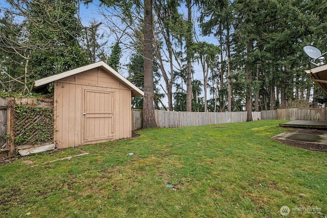 view of yard with an outbuilding, a storage unit, and a fenced backyard