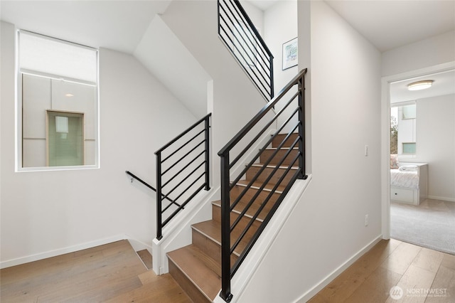 stairway with wood finished floors and baseboards