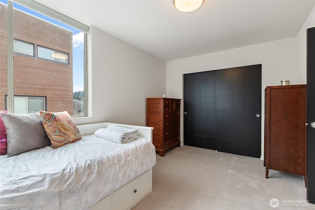 bedroom with light carpet and multiple windows