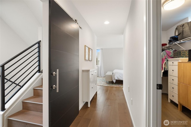 corridor featuring stairs, recessed lighting, wood-type flooring, and baseboards