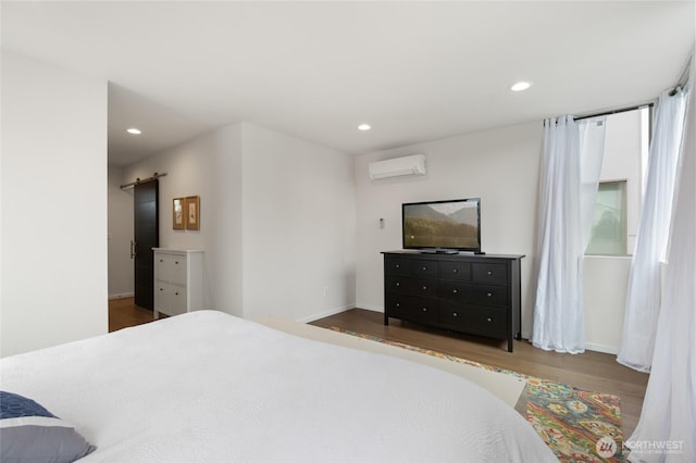 bedroom featuring recessed lighting, wood finished floors, and a wall mounted AC