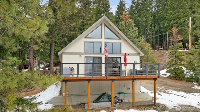 rear view of property featuring a wooden deck