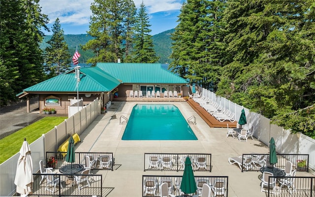 pool featuring a fenced backyard, a mountain view, outdoor dining area, and a patio