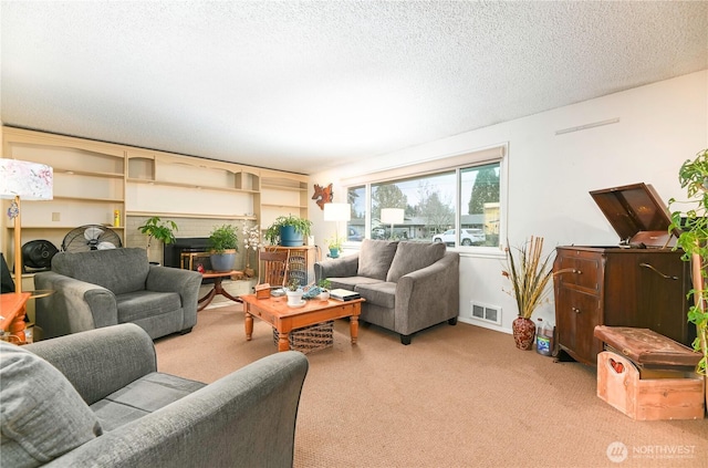 living room featuring a textured ceiling, carpet, a fireplace, and visible vents