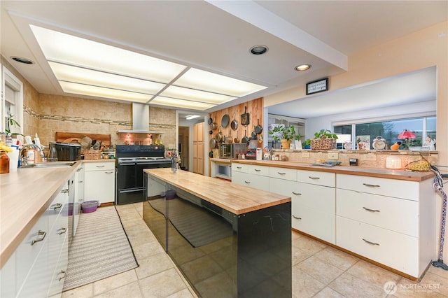 kitchen with white cabinetry, wooden counters, electric range, and wall chimney exhaust hood