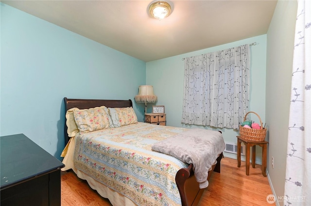 bedroom with visible vents, baseboards, and wood finished floors