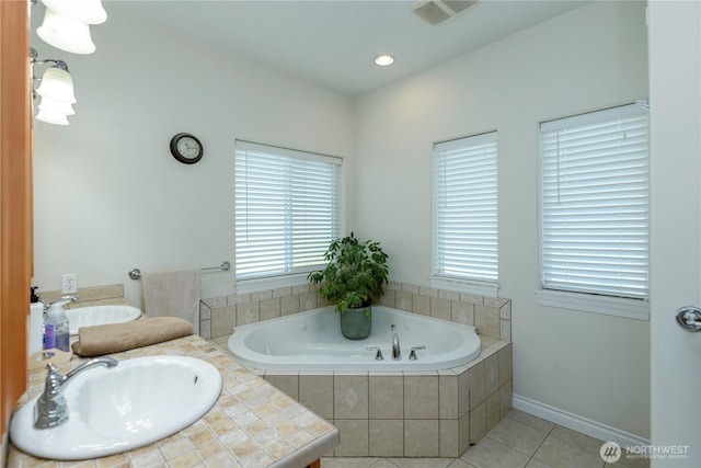 bathroom with a bath, a sink, and tile patterned floors