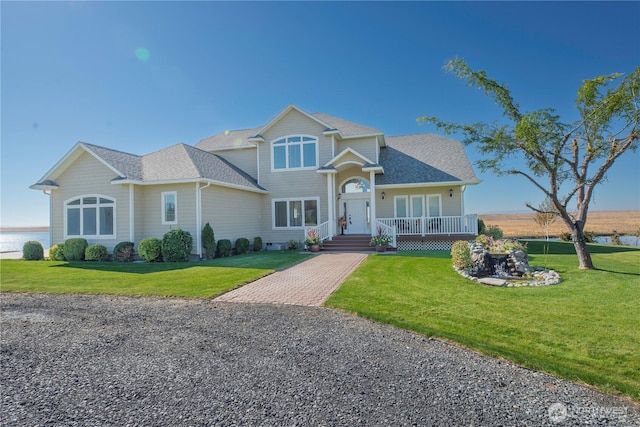 view of front of home featuring a front lawn and roof with shingles