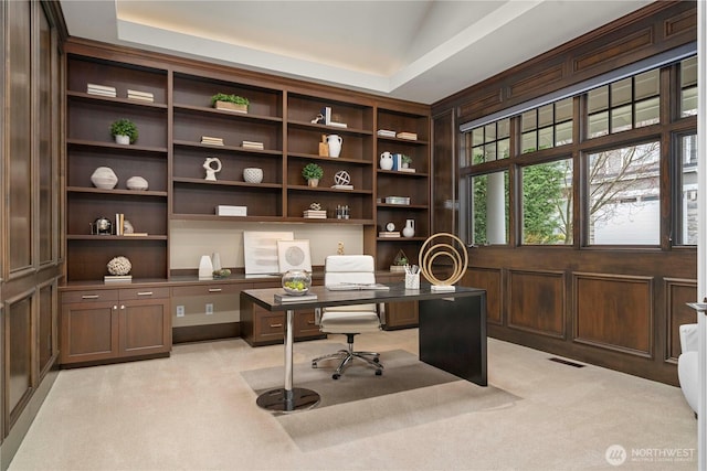 office space featuring built in study area, light carpet, and visible vents