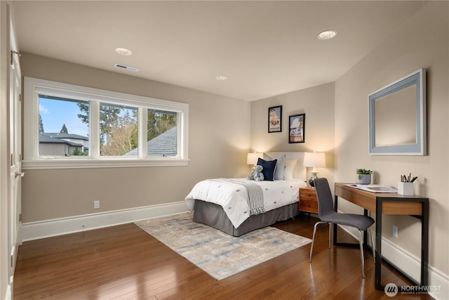 bedroom with baseboards, visible vents, and dark wood-style floors