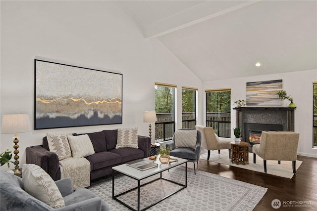 living room with high vaulted ceiling, a glass covered fireplace, beamed ceiling, and wood finished floors