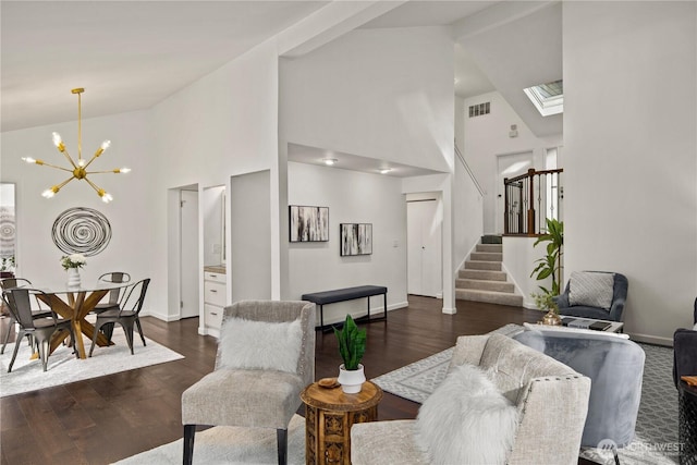 living room with dark wood-type flooring, visible vents, high vaulted ceiling, and stairway