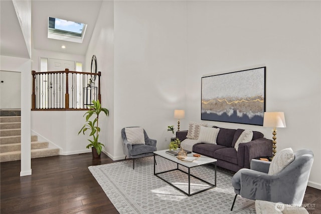 living room featuring stairs, hardwood / wood-style floors, a skylight, and baseboards