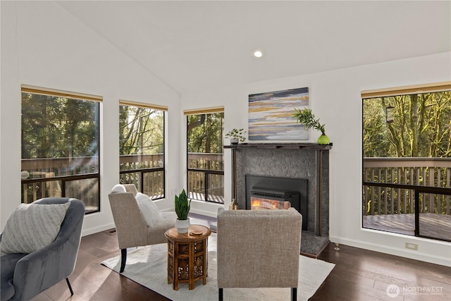 interior space with lofted ceiling, recessed lighting, a fireplace, wood finished floors, and baseboards