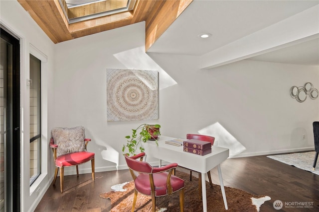 office space featuring a skylight, recessed lighting, baseboards, and wood finished floors