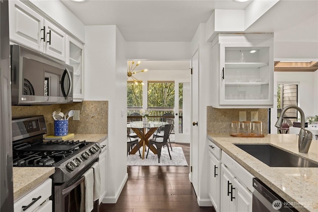 kitchen featuring dark wood-type flooring, a sink, white cabinets, appliances with stainless steel finishes, and glass insert cabinets