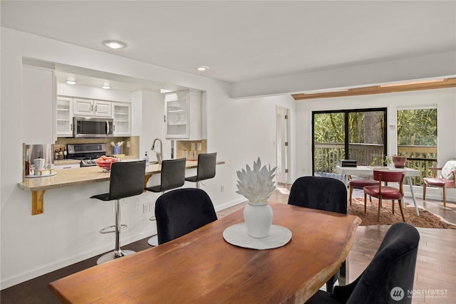 dining room with recessed lighting, baseboards, and wood finished floors