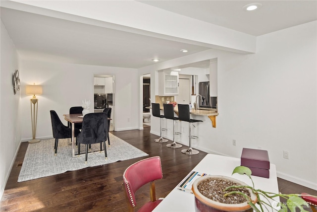 dining room with dark wood-type flooring and baseboards