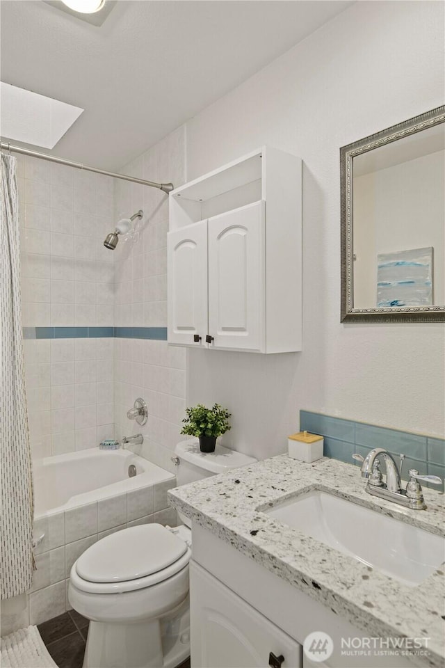 full bath featuring tiled shower / bath combo, vanity, toilet, and tile patterned floors