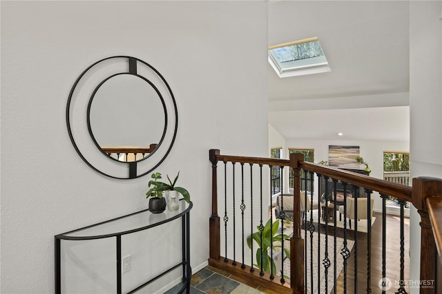 hallway featuring a skylight and baseboards