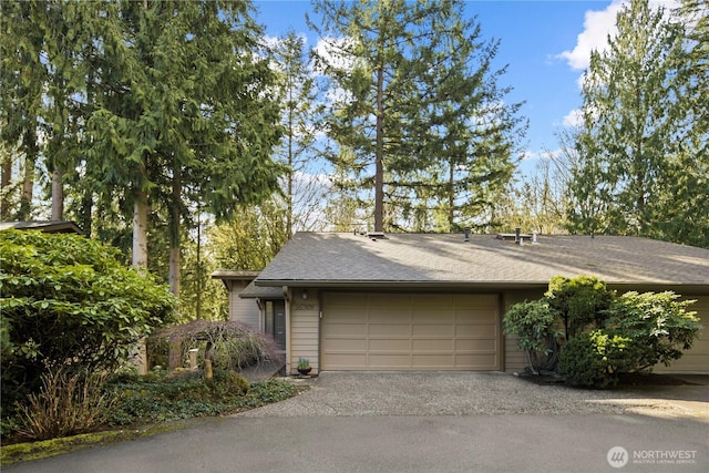 view of front of home featuring an attached garage, a shingled roof, and aphalt driveway