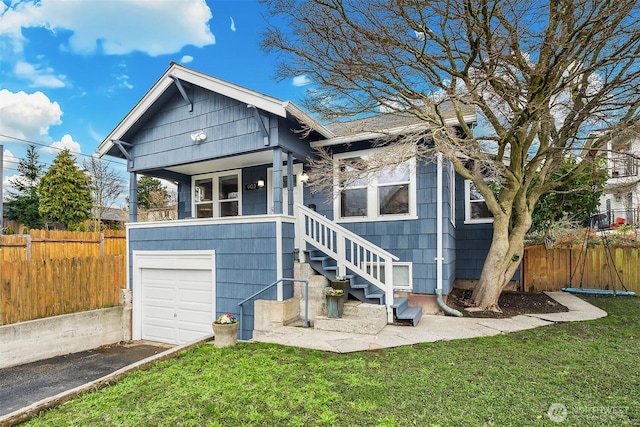 view of front facade with a garage, a front lawn, and fence