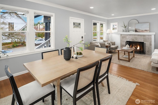 dining area with a wealth of natural light, ornamental molding, and wood finished floors