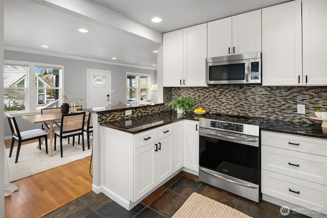 kitchen featuring tasteful backsplash, appliances with stainless steel finishes, crown molding, and a peninsula