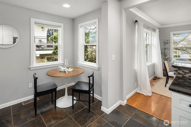 dining area with baseboards, plenty of natural light, and stone tile floors