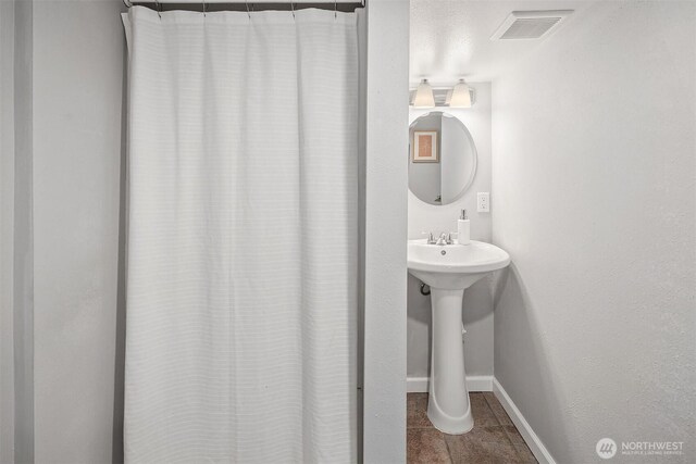 full bathroom with a sink, visible vents, baseboards, and tile patterned floors