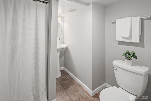 bathroom with a shower with shower curtain, visible vents, baseboards, and toilet